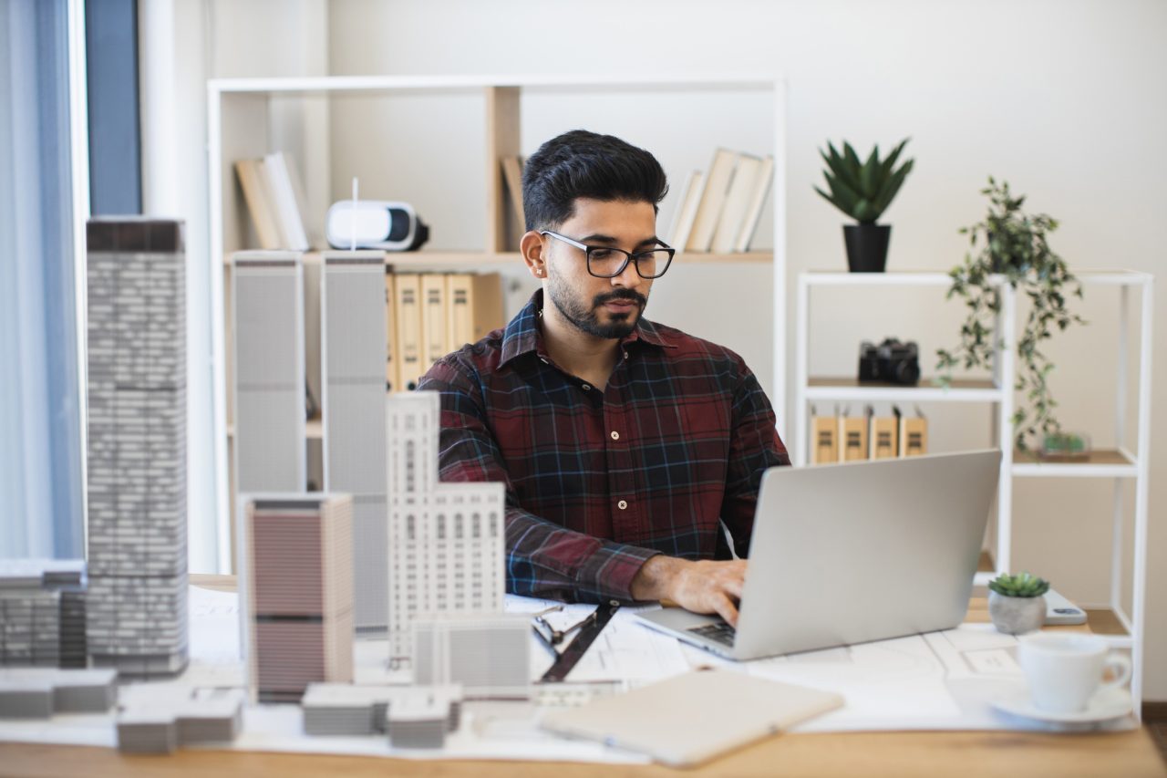 young indian architect designing modern urban skyscrapers